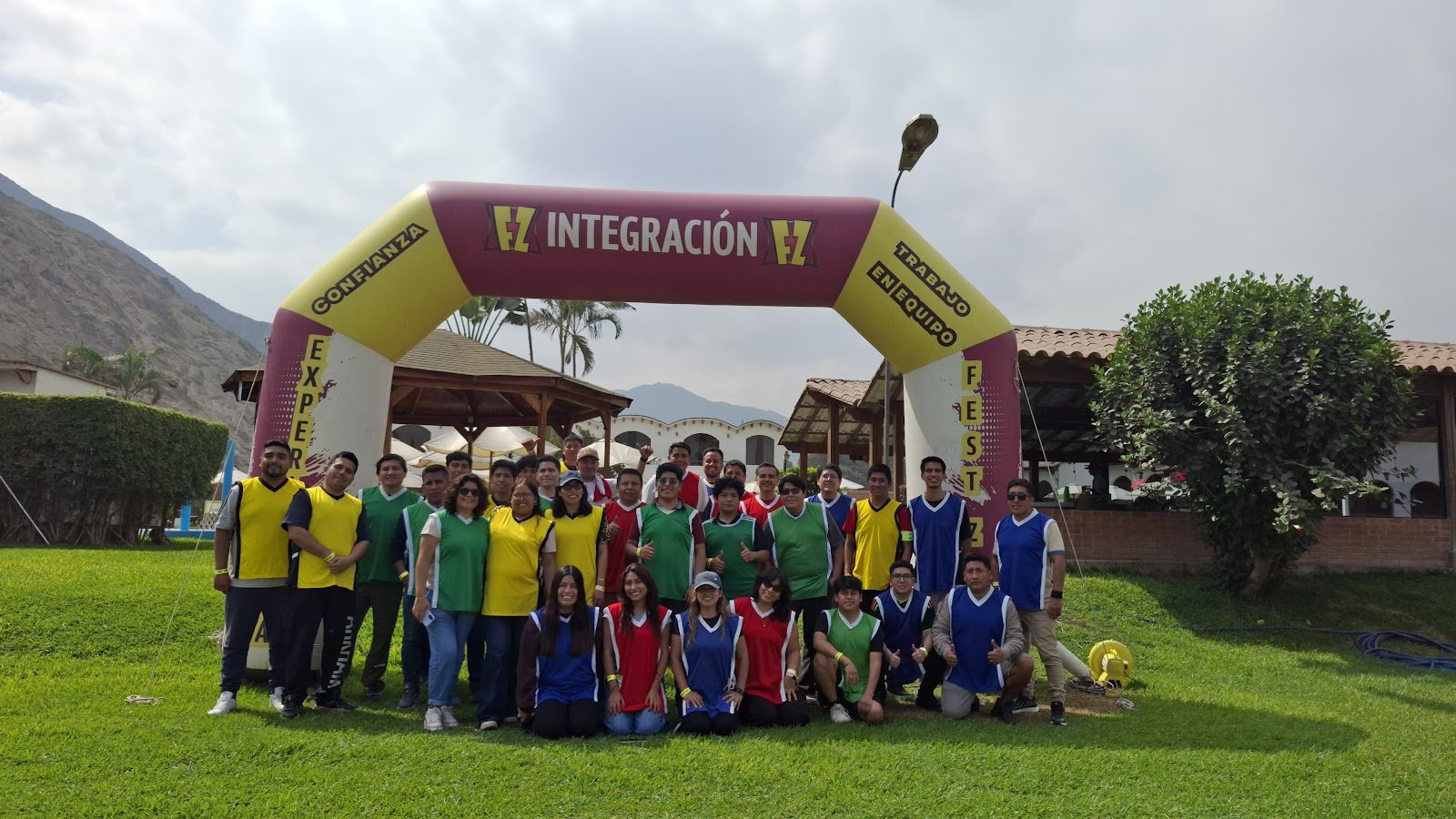 Colaboradores divididos en equipos por colores bajo el arco de integración de ZVENTS en Lima