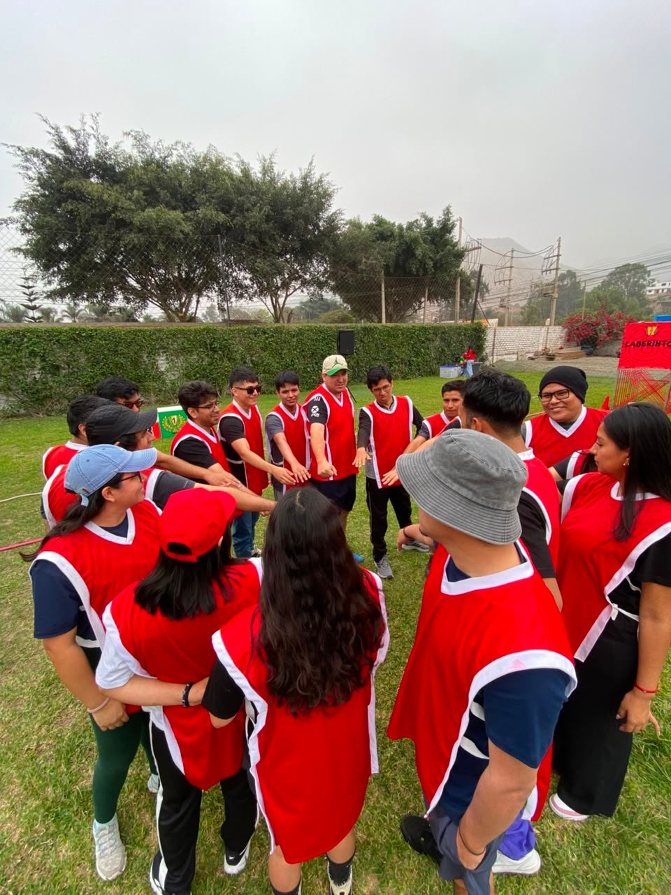 Equipo de empresa unido en círculo durante una dinámica de integración en Lima